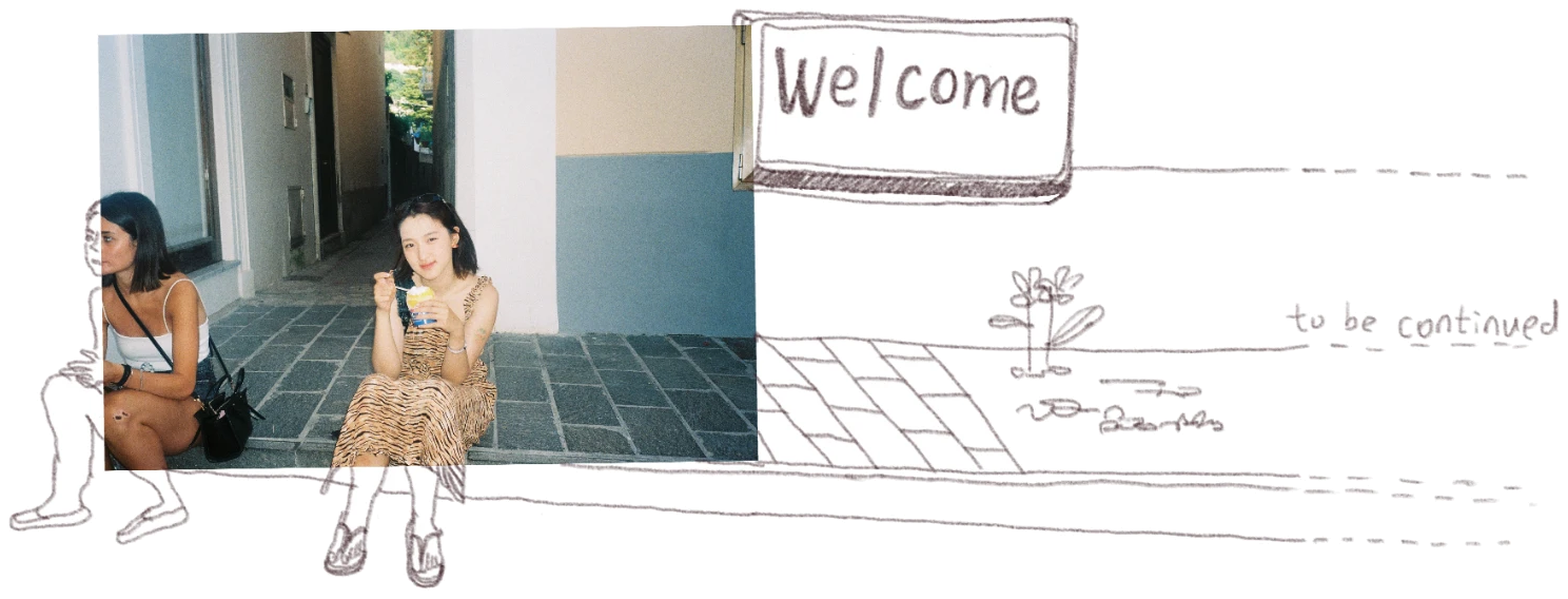 Emma and a friend sitting outside eating dessert, with a hand-drawn Welcome sign and a doodled path